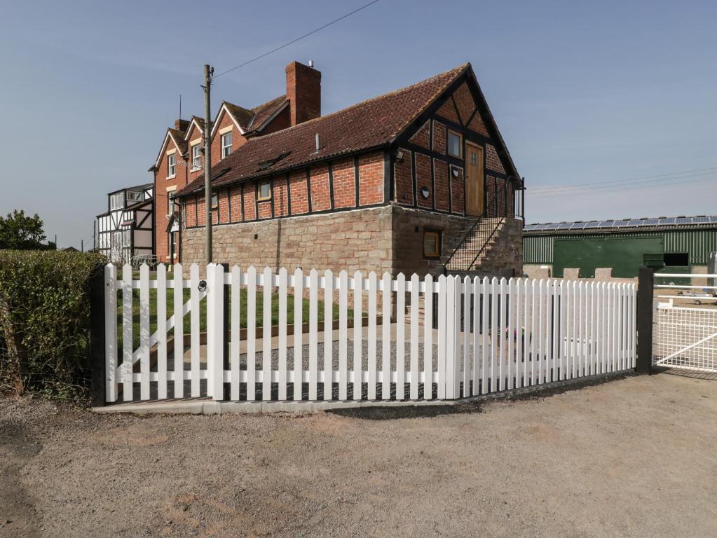 a white picket fence in front of a house at Lower Venn Granary Apartment 2 in Wellington