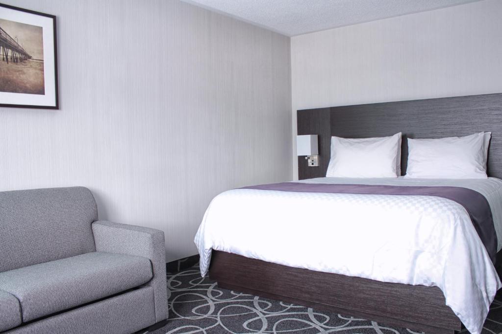 a hotel room with a bed and a chair at Stonecroft Inn in Windsor