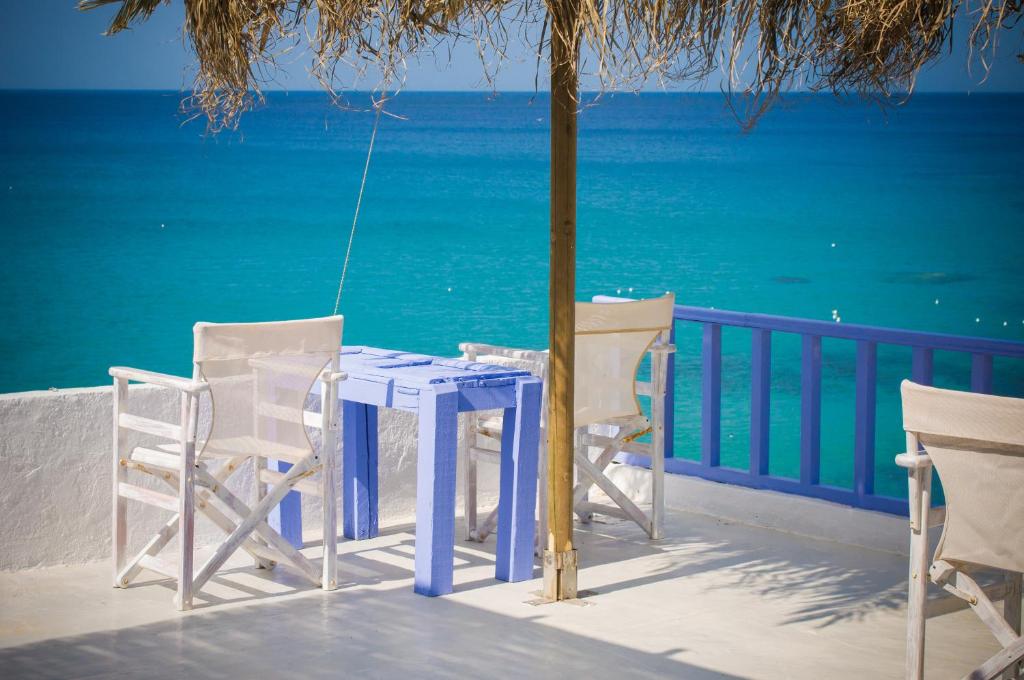 a blue table and chairs on a balcony with the ocean at Κymanemi Folegandros in Agali