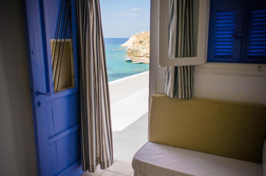 a view of the ocean from a room with a blue door at Κymanemi Folegandros in Agali