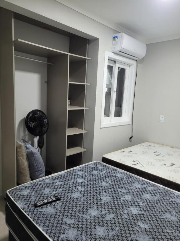 a bedroom with a bed and a closet at Novo Lar Garopaba1 in Garopaba