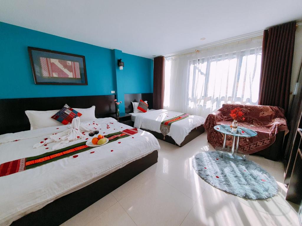 una habitación de hotel con 2 camas y una silla en Sapa New Orient Hotel, en Sa Pa