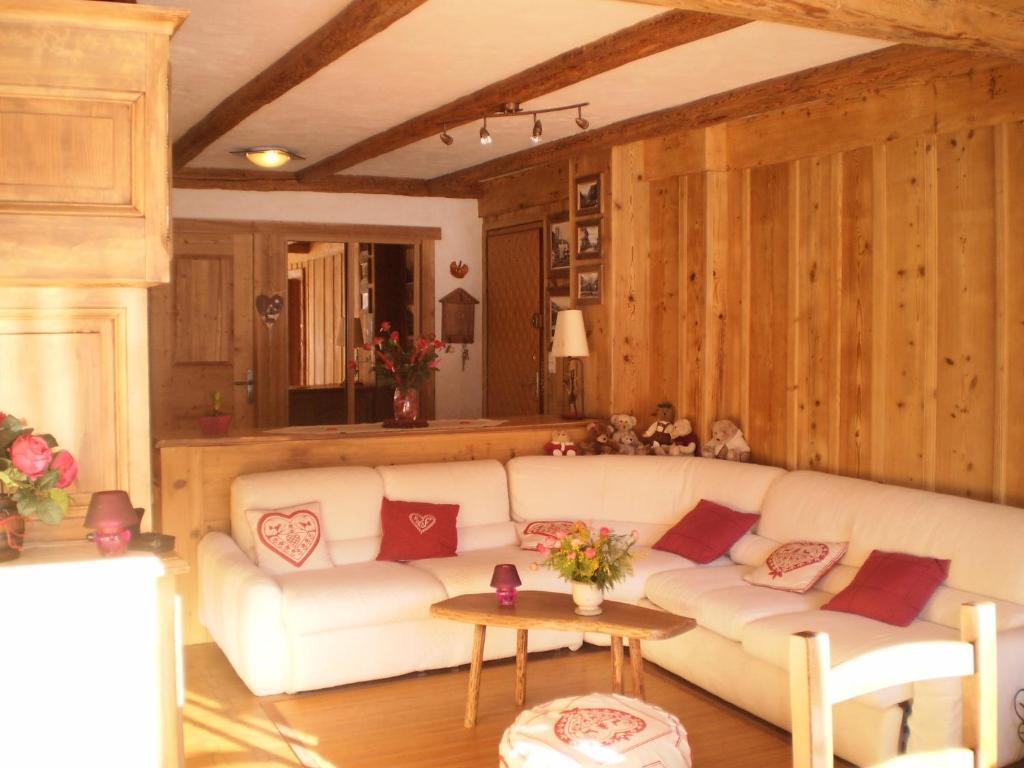 ein Wohnzimmer mit einem weißen Sofa und einem Tisch in der Unterkunft Appartement La Montagne in Les Gets