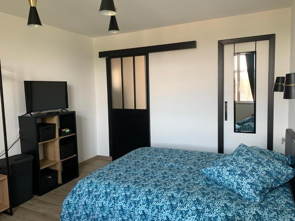 Schlafzimmer mit einem Bett und einer Glasschiebetür in der Unterkunft Gite les Combes Bellevue à Etrez, Appartement à la campagne in Étrez