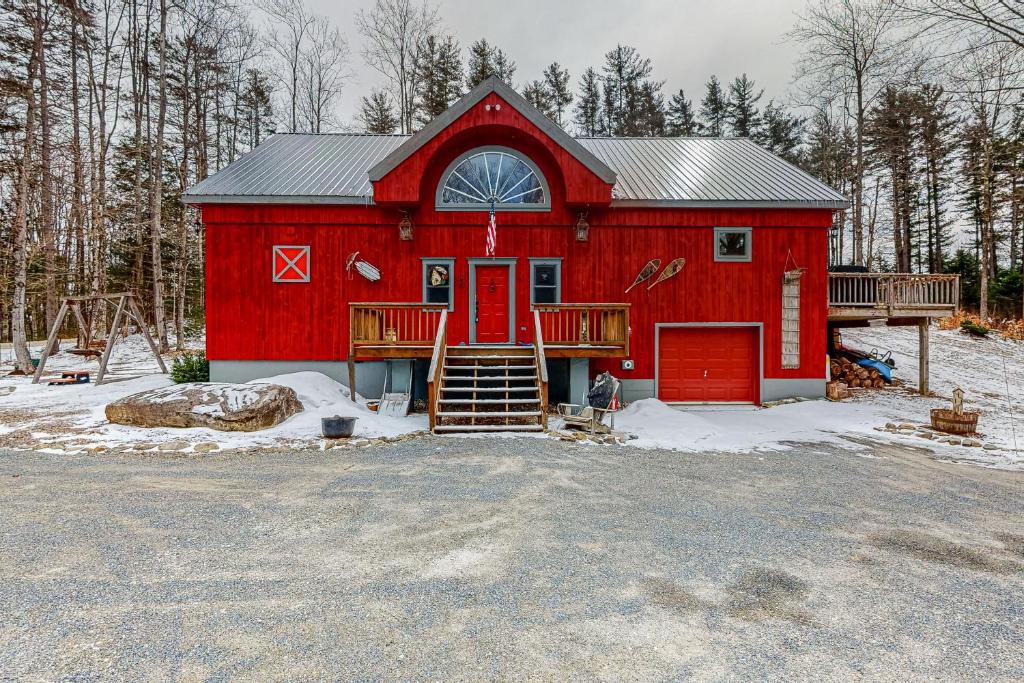 a red barn with a red door in the snow at Vision in Strattonwald