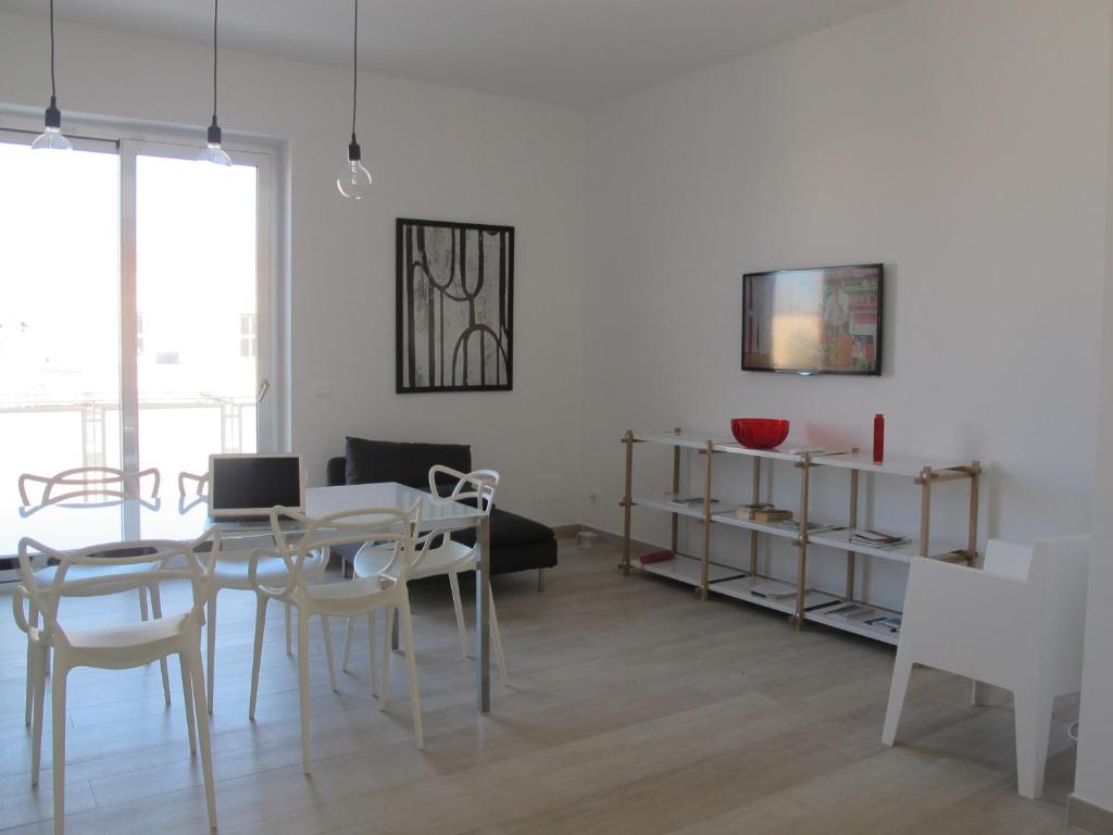 a living room with a table and chairs and a couch at Penthouse Santa Croce in Lecce