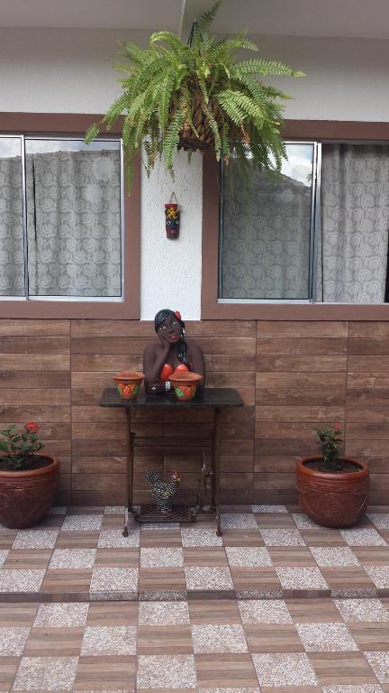 a statue sitting on top of a table with fruit at Recanto do Carreiro in Trindade