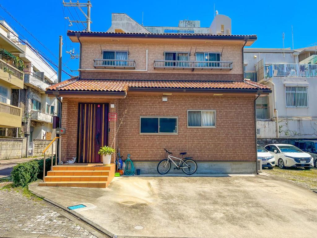 a house with a bike parked in front of it at B&B 4 Rooms in Naha