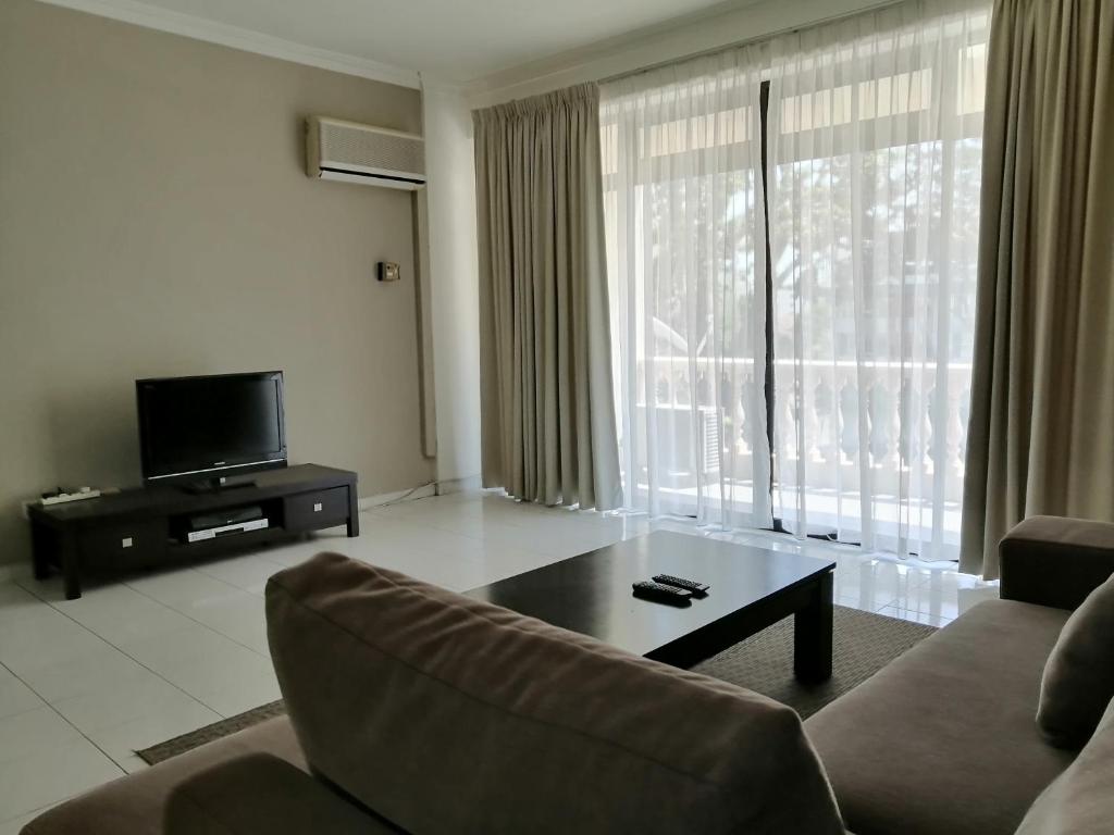 a living room with a couch and a coffee table at Noble Villa Apartment in George Town