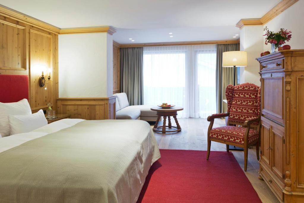 a hotel room with a bed and a chair at ElisabethHotel Premium Private Retreat- Adults only in Mayrhofen
