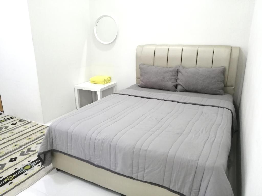 una camera da letto con un letto con copriletto bianco di Simple Home by Aimie Fully Aircond a Dungun