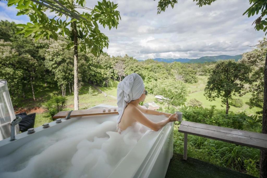 a woman in a bathtub filled with foam at แคมป์ต๊ะต่อนยอน แม่กำปอง เชียงใหม่ CAMP Ta-Torn-Yorn Maekampong Chiang Mai in Mae On