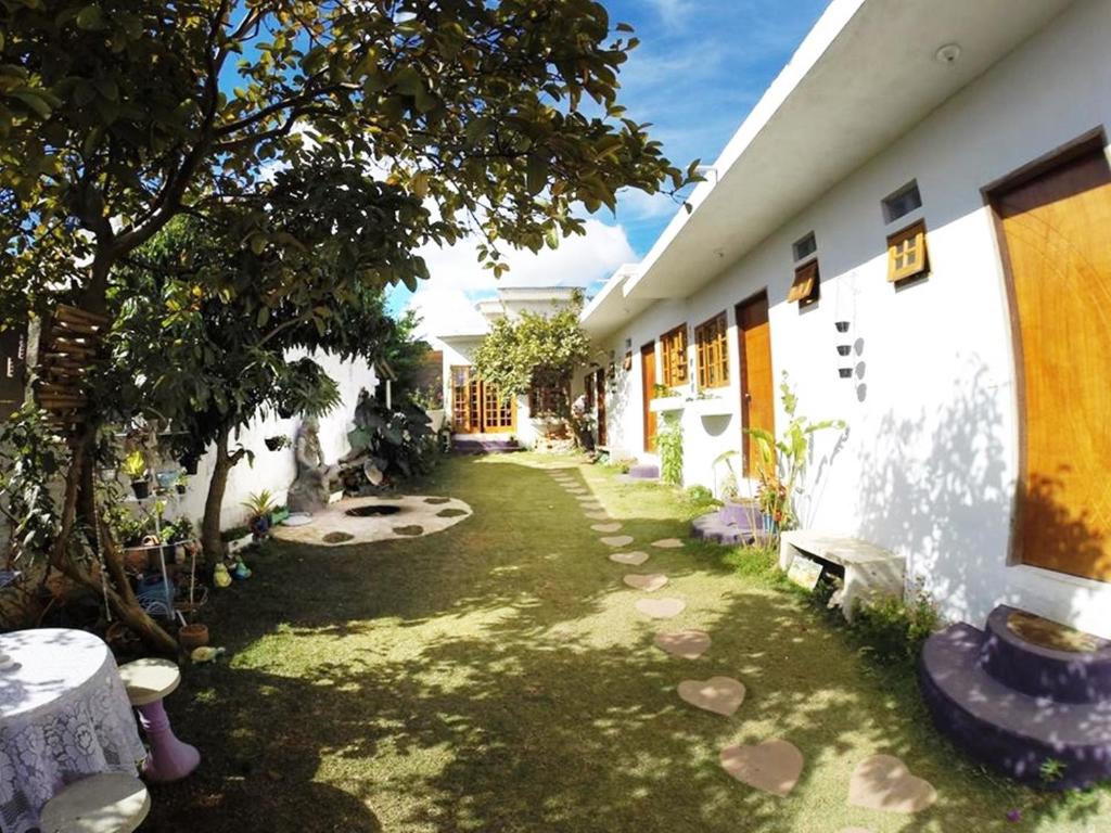 a courtyard of a house with a tree in the yard at Pousada Namastê in São Thomé das Letras