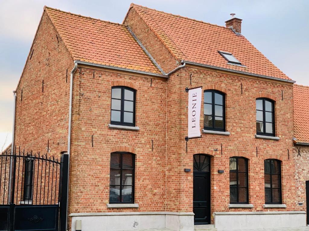 a red brick building with a sign on it at Vakantievilla Leonie in Lo-Reninge