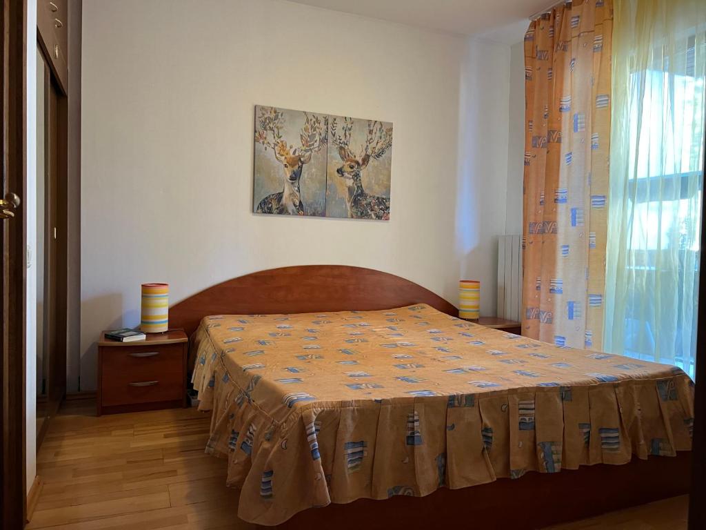 een slaapkamer met een bed met een deken erop bij Muller Apartment in Sinaia