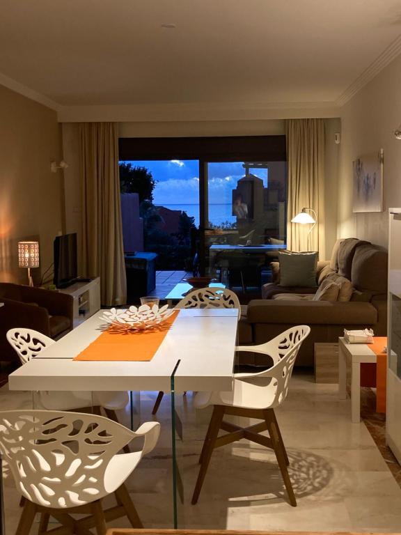 sala de estar con mesa blanca y sillas en La Galera, en Estepona