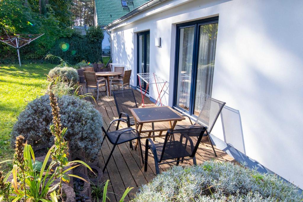 a deck with tables and chairs on a house at Ferienanlage Zum Knirk in Lubmin