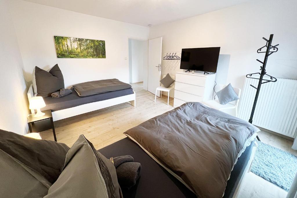 a living room with a bed and a flat screen tv at Cozy House in Zirndorf near Nürnberg in Zirndorf