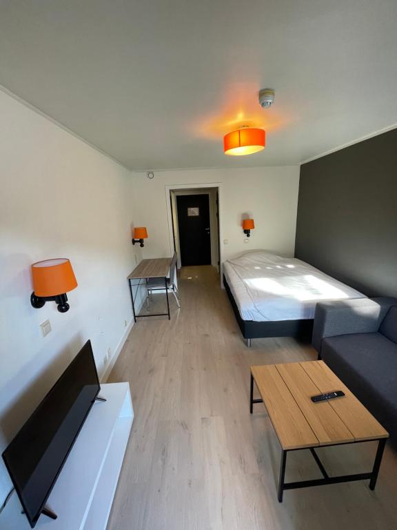 Habitación con cama, sofá y mesa. en Namsen Hotell en Namsos