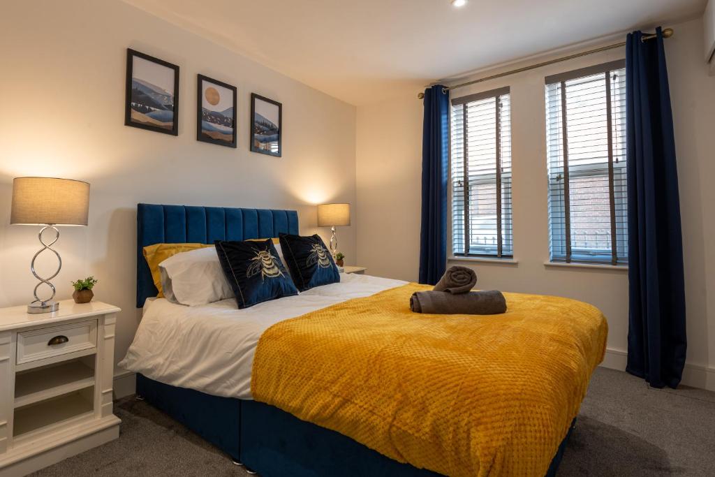a bedroom with a large bed with a yellow blanket at 5 MINS To CENTRAL - LONG STAY OFFER - FREE PARKING in Strood