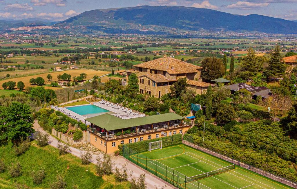 eine Luftansicht eines Herrenhauses mit Tennisplatz in der Unterkunft Il Poggio degli Olivi in Bettona