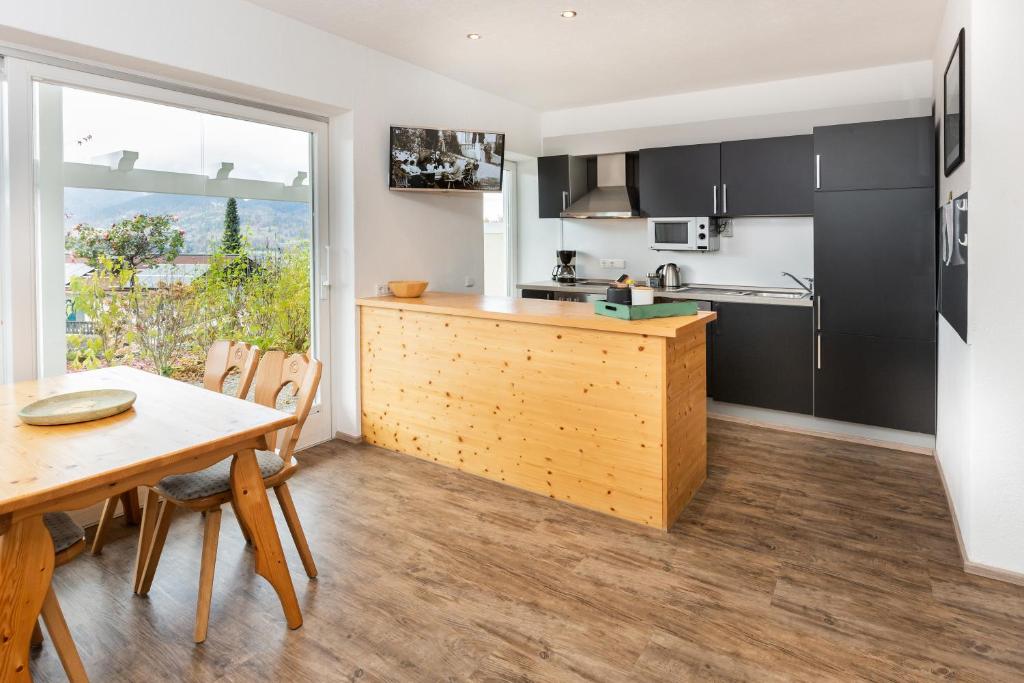 eine Küche und ein Esszimmer mit einem Tisch und einem Fenster in der Unterkunft Villa am First in Oberstdorf