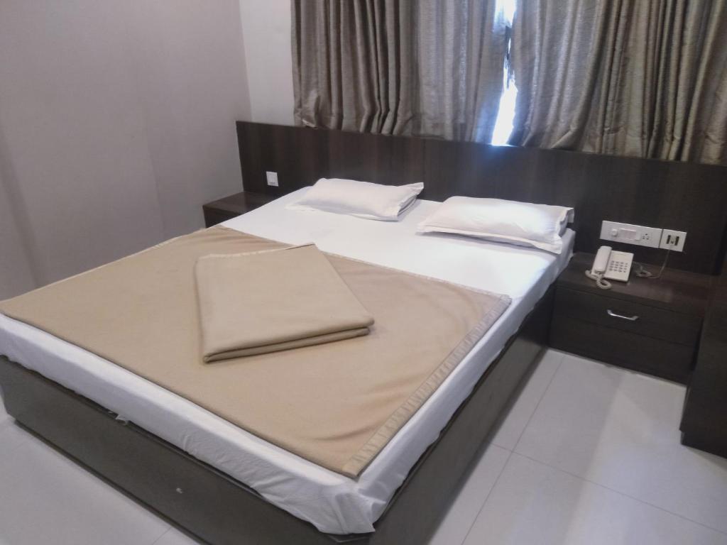 Postel nebo postele na pokoji v ubytování Sai Heera Residency Shirdi