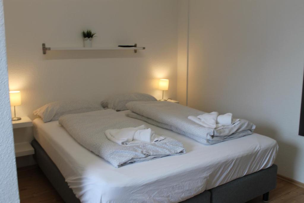 Bett in einem Zimmer mit zwei Kissen darauf in der Unterkunft Boardinghouse Georgsheil in Südbrookmerland