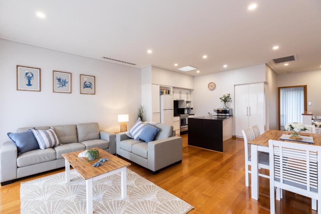 ein Wohnzimmer mit einem Sofa und einem Tisch in der Unterkunft Promenade Unit 4 in Geraldton