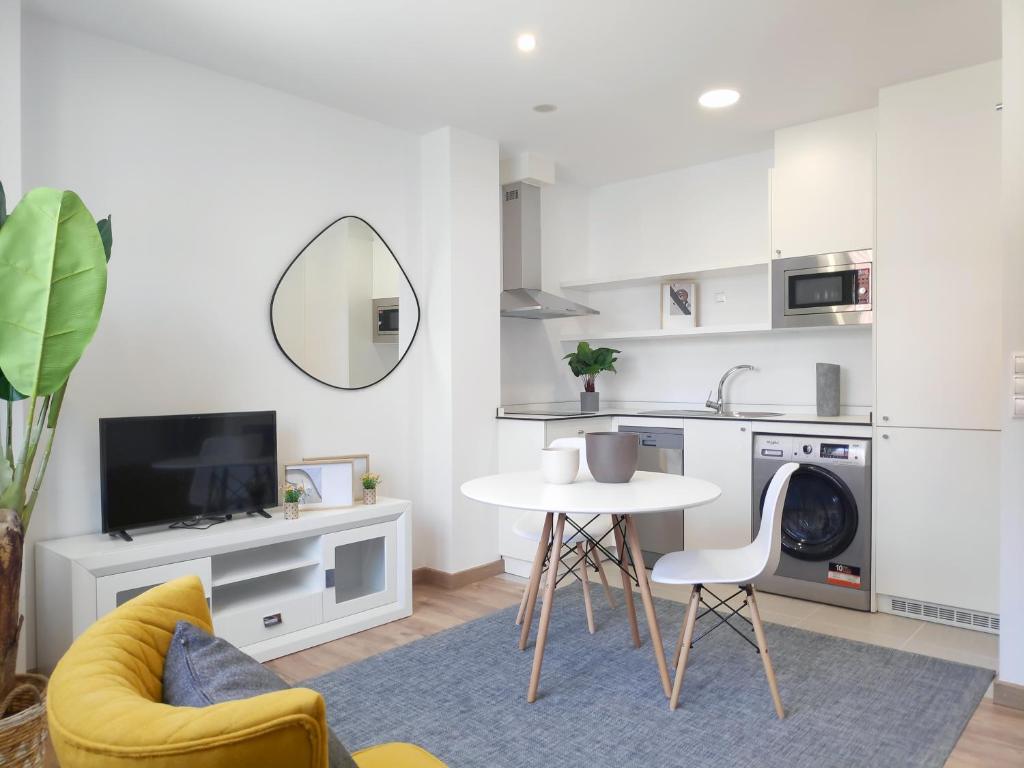 cocina y sala de estar con mesa y fregadero en Apartamentos Rey by Como en Casa en Santiago de Compostela