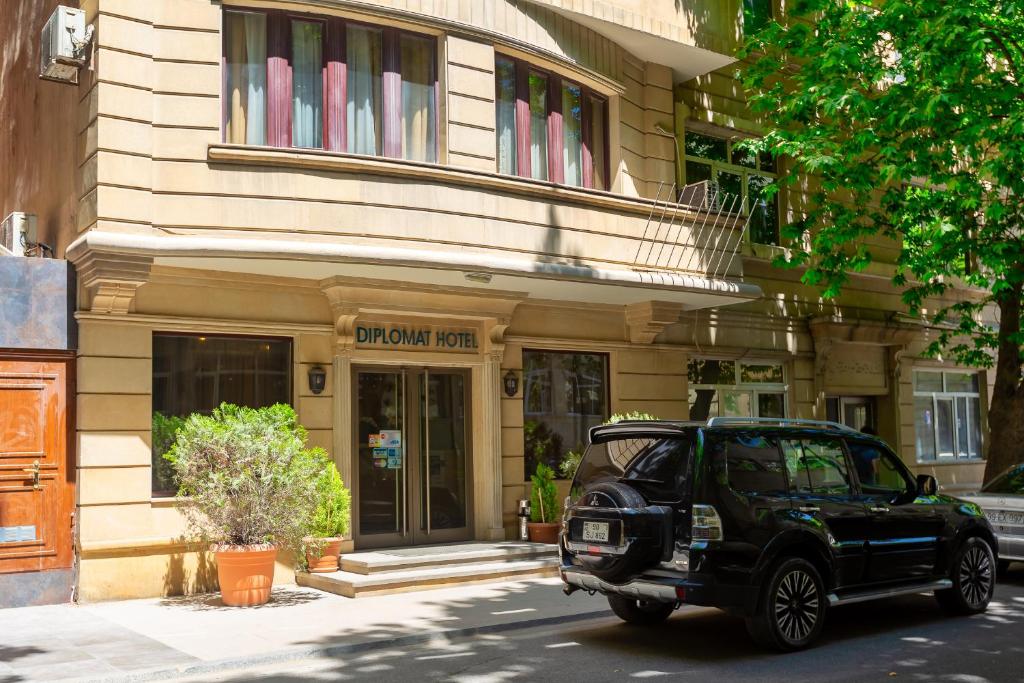 une jeep noire garée devant un bâtiment dans l'établissement Diplomat Hotel Baku, à Baku