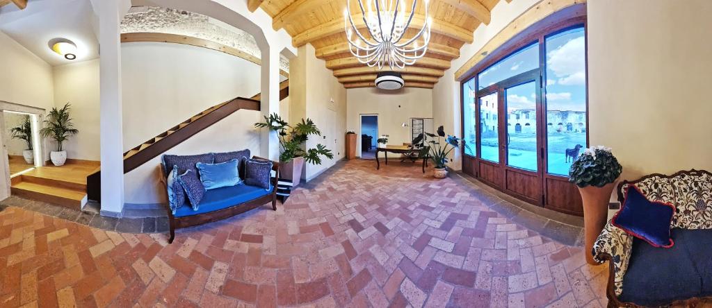 sala de estar con sofá azul y ventana grande en Corte degli OstiNati en Variano