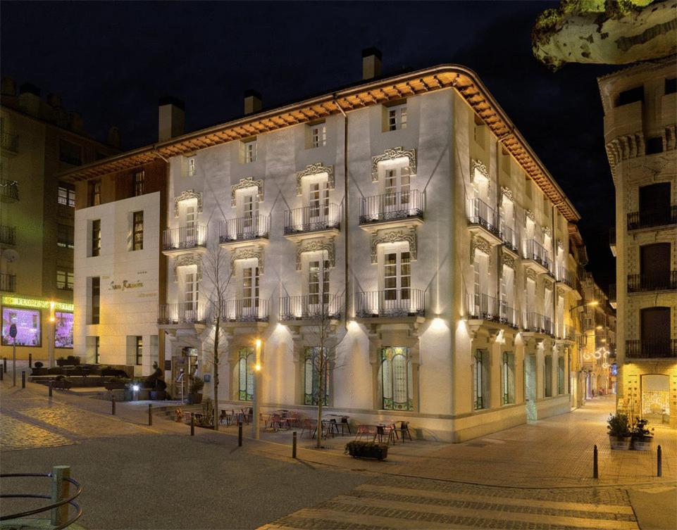 un gran edificio blanco con ventanas iluminadas por la noche en San Ramón del Somontano, en Barbastro