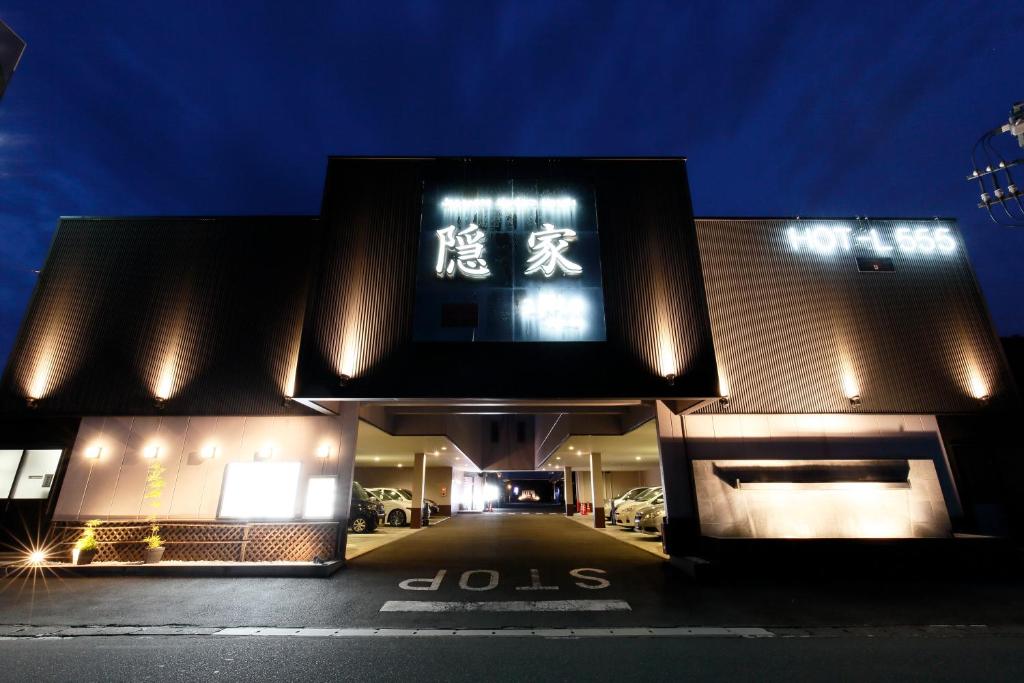 a building with a sign on it at night at 隠家（ajito）HOTEL555 小田原店 in Kami-soga