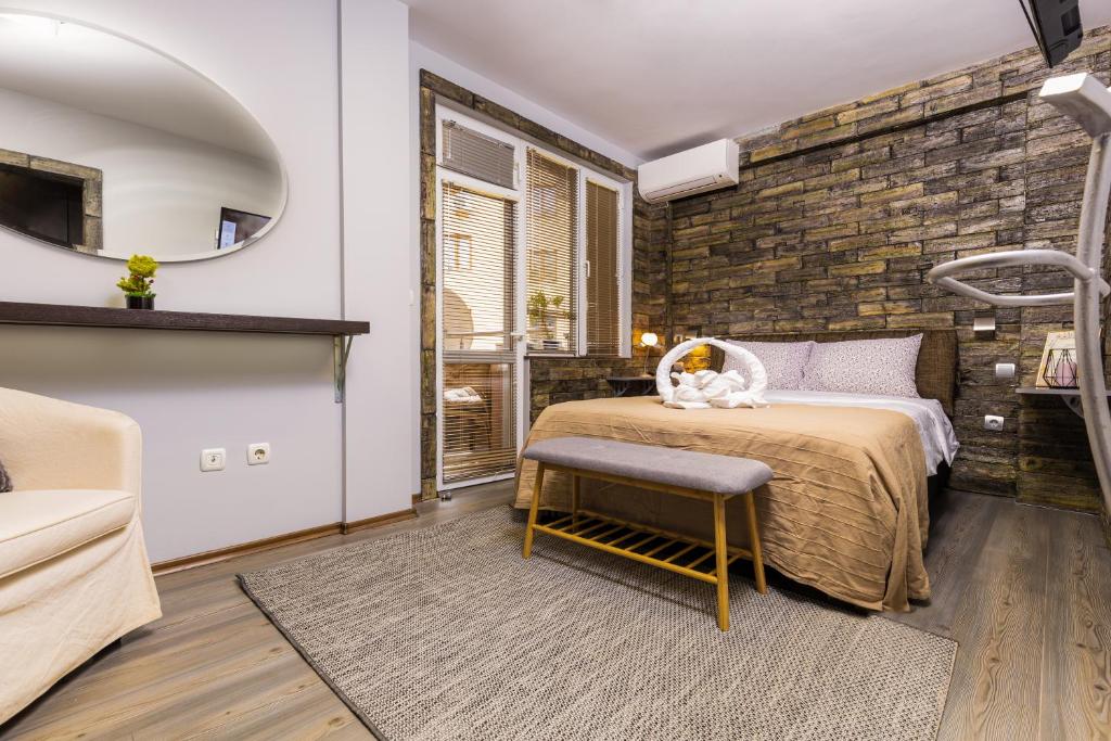a bedroom with a bed and a brick wall at 1BD flat with a Garage - 5 mins to the city centre in Plovdiv