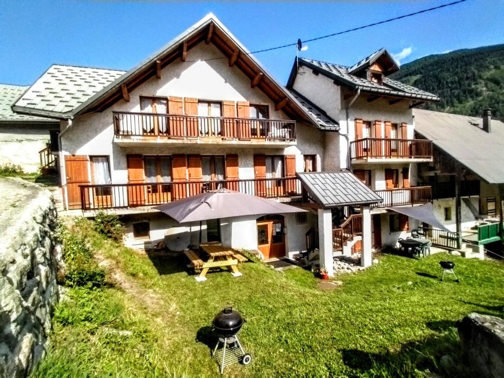 a house with an umbrella in front of it at Résidence Le Martinan in Saint-Colomban-des-Villards