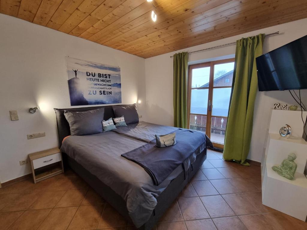 ein Schlafzimmer mit einem Bett und einem großen Fenster in der Unterkunft Ferienwohnung Am Golfplatz in Wallgau