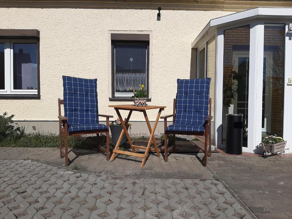 two chairs and a table in front of a house at Gartenblick Trebbin in Trebbin