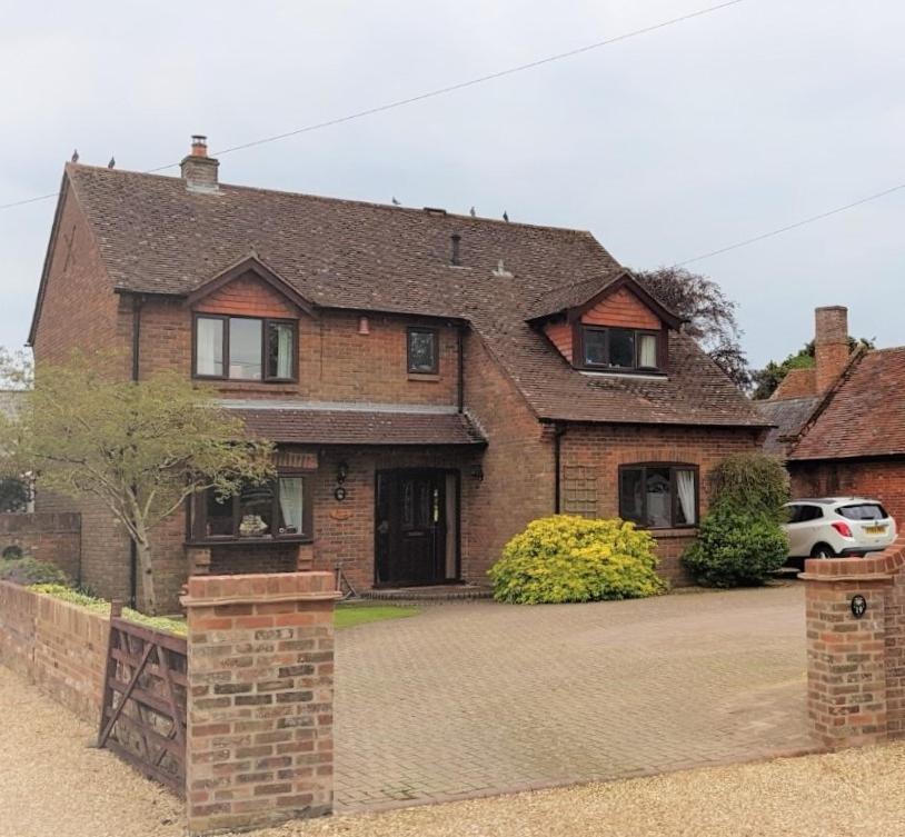 a brick house with a car parked in the driveway at Barn Court Bed and Breakfast in Everton