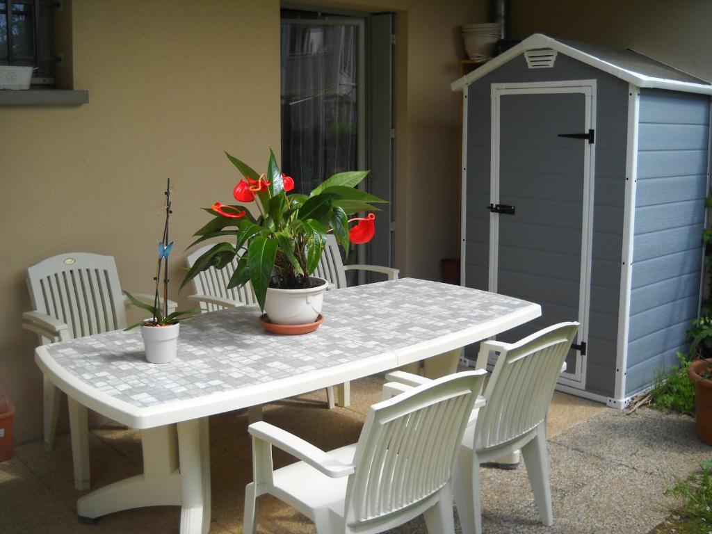 a table and chairs with a table and a shed at grand appartement en résidence in Vendôme