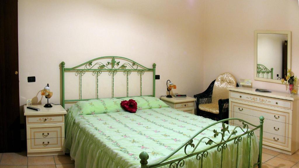 a bedroom with a green bed and two dressers at Il Centro Storico in Posta Fibreno