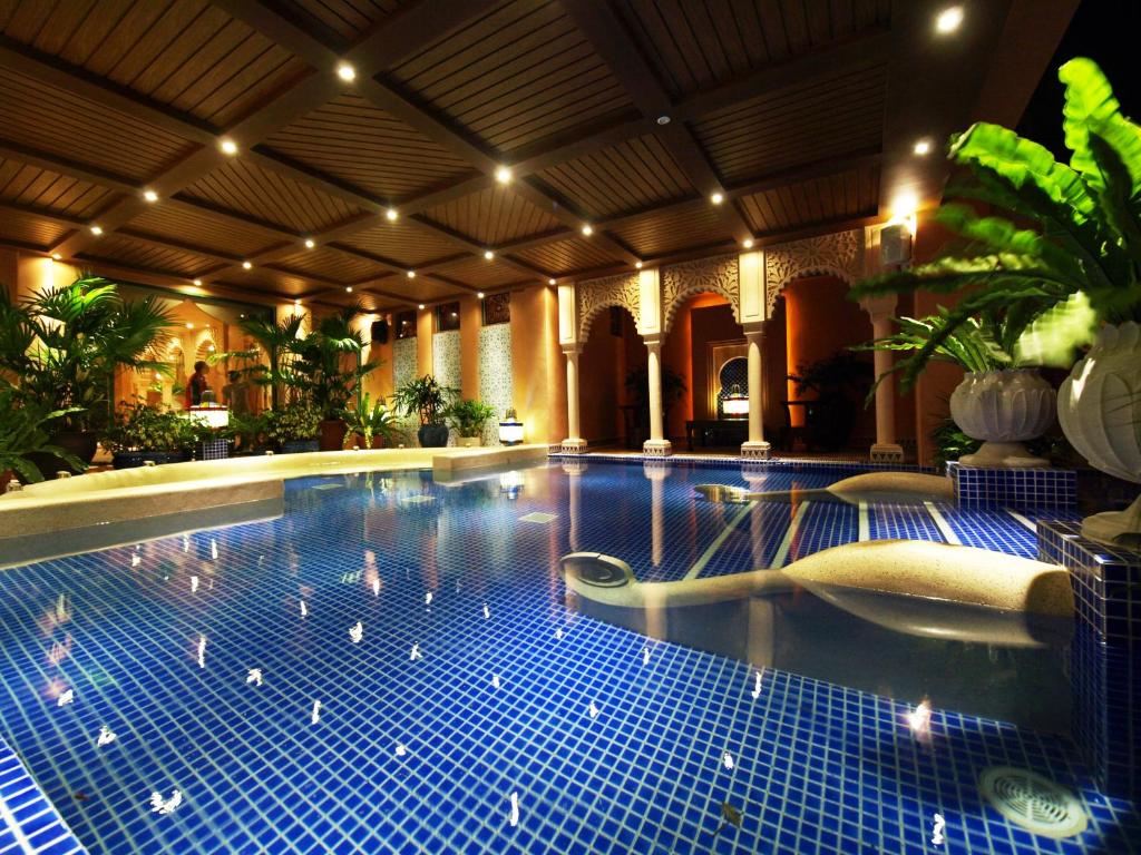a large swimming pool with blue tiles in a building at Kenting Amanda Hotel in Nanwan