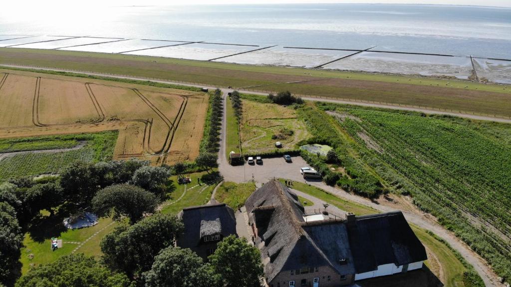 an aerial view of a farm next to the ocean at Gräfinhof in Nordstrand