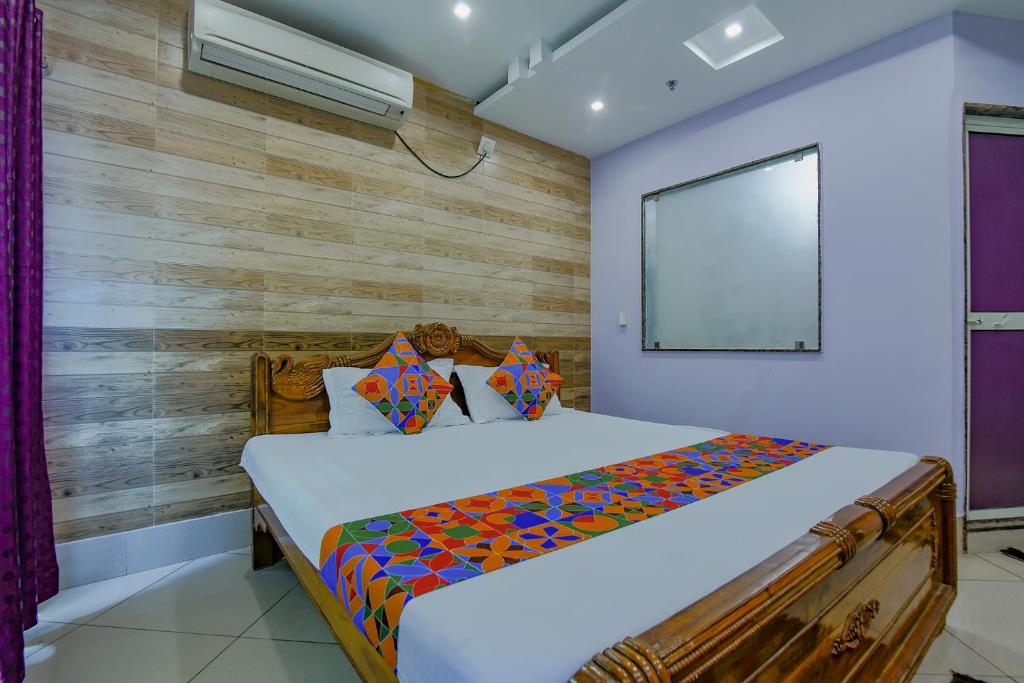 um quarto com uma cama e uma parede de madeira em FabHotel New Central em Bhubaneshwar
