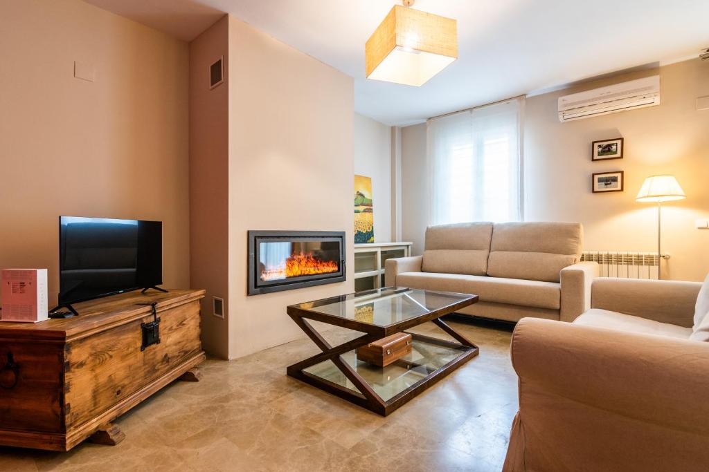 a living room with a couch and a tv and a table at tuGuest Grisolia House in Armilla