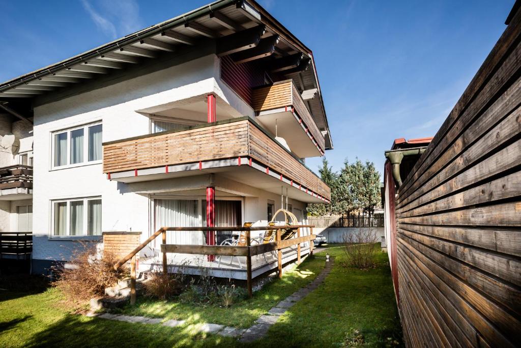 a house with a wooden fence next to a yard at Zweistapfenweg 9a in Oberstdorf