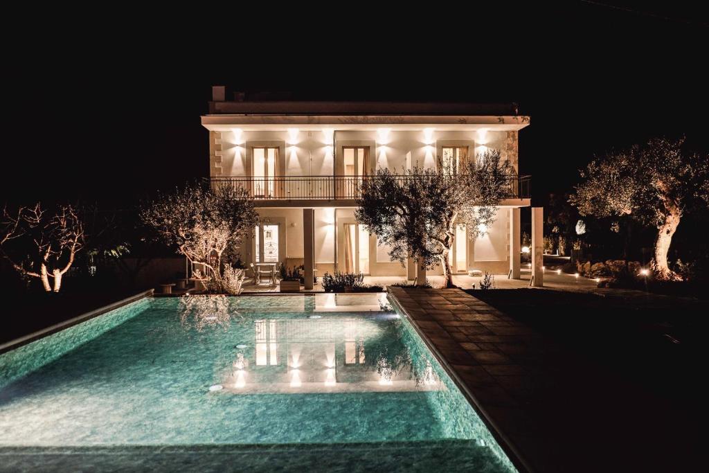 uma casa com piscina à noite em ALMASOL - Charme Experience em Castellana Grotte