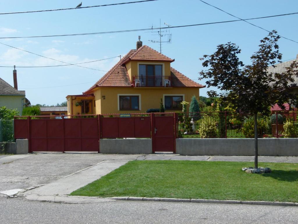 a house with a red fence in front of it at Privat u Jozefa Földesa in Veľký Meder