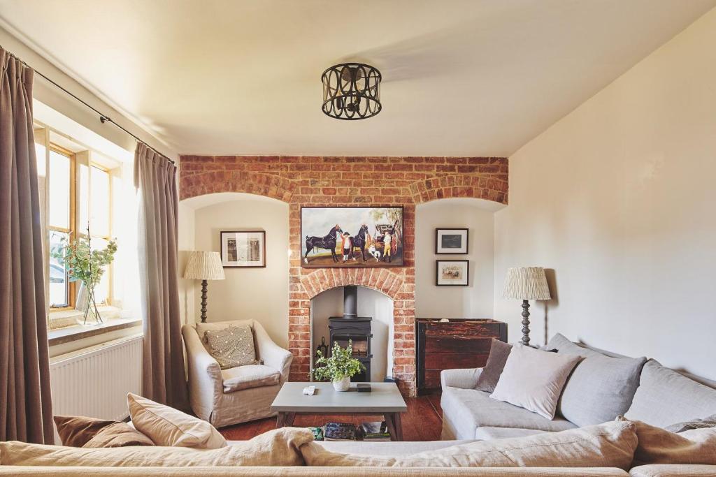 a living room with a couch and a fireplace at Large Stylish Luxury Cotswold Cottage - ideal for families, w/ EV charging in Andoversford