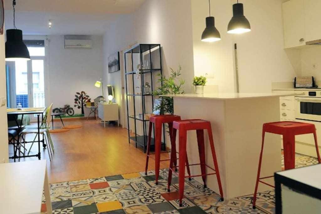 eine Küche mit roten Hockern und einer Theke in einem Zimmer in der Unterkunft Modern Apartment in Barcelona